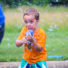 Young boy camper with a bubble gun toy shooting bubbles