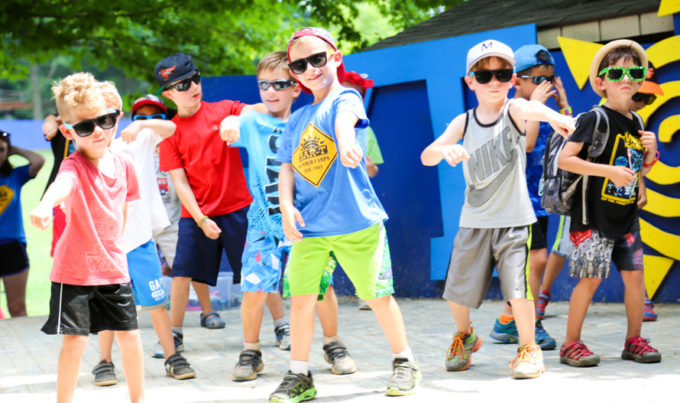 Campers on stage outside dancing with sunglasses on