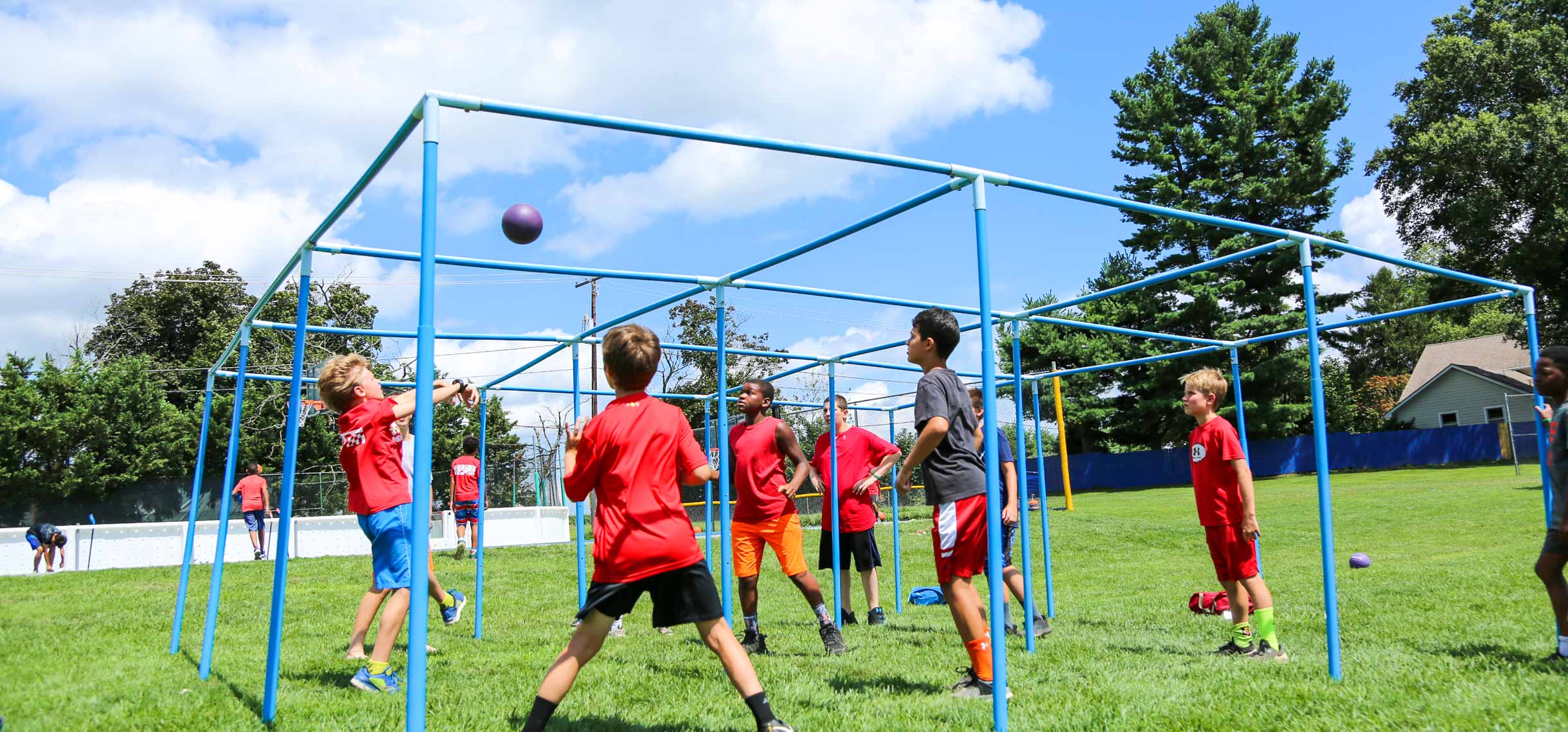 Campers playing a game with a ball and a plastic framing