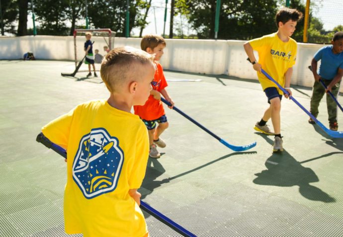 Campers playing street hockey